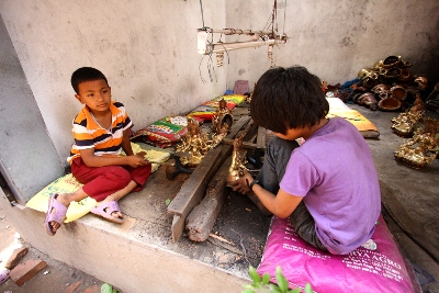 https://archive.nepalitimes.com/assets/uploads/gallery/89bf3-Boys-work-on-Buddhist-figurines-in-an-empty-shop-in-Patan-on-Monday-afternoon.jpg